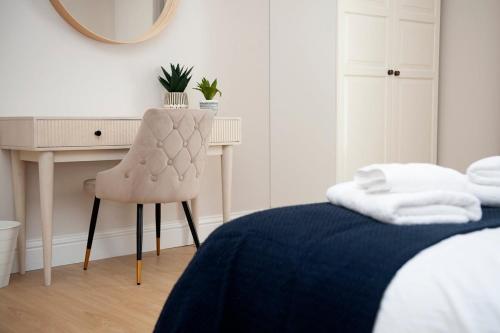 a bedroom with a bed and a desk and a chair at Fresh and spacious 3 bedroom home in Angus