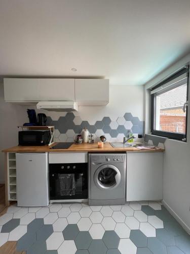 une petite cuisine avec un lave-linge. dans l'établissement Appartement neuf 1 Chambre en rez de jardin avec, à Lovagny