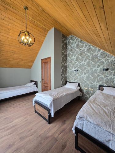 una camera da letto con due letti e soffitto in legno di Kazbegi Folk Cottages a Kazbegi