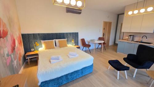 ボシュコボにあるBoszkowo Horizon Park Apartament 14 "Laguna"の大きなベッドとキッチンのある寝室