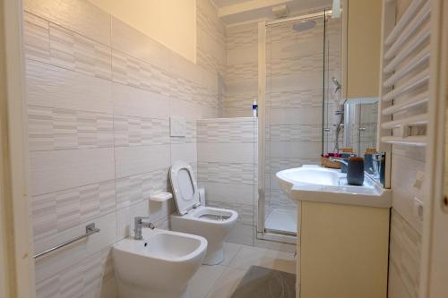 Un baño blanco con inodoro y lavabo. en Antonelli Apartment, en Terracina