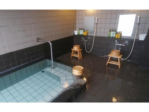 a bathroom with a shower and a tub with two stools at Hotel AreaOne Chitose - Vacation STAY 99105v in Chitose