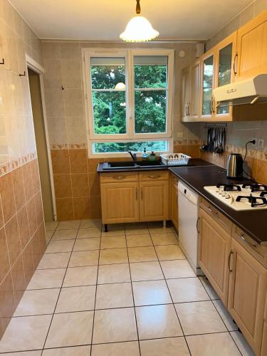 - une cuisine avec des placards en bois et des appareils blancs dans l'établissement L'impasse de l'Orée du Bois, à Joué-lès-Tours