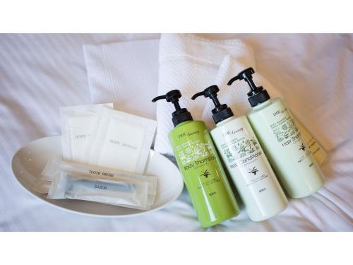 a group of three shampoo and conditioners on a bed at Hotel AreaOne Chitose - Vacation STAY 99105v in Chitose