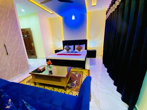 a living room with a blue couch and a bed at Moonlight Guest House in Rawalpindi