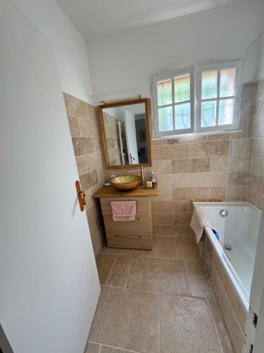 une salle de bain avec une baignoire, un lavabo et un miroir dans l'établissement Cannes hills villa with garden and parking, au Cannet