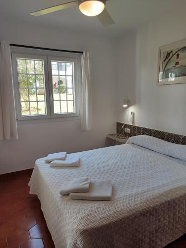 Un dormitorio con una cama con dos toallas encima. en Apartamento colibrí, en Alaior