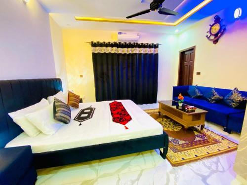 a bedroom with a bed and a blue couch at Moonlight Guest House in Rawalpindi