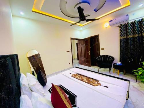 a living room with a bed and a ceiling fan at Moonlight Guest House in Rawalpindi
