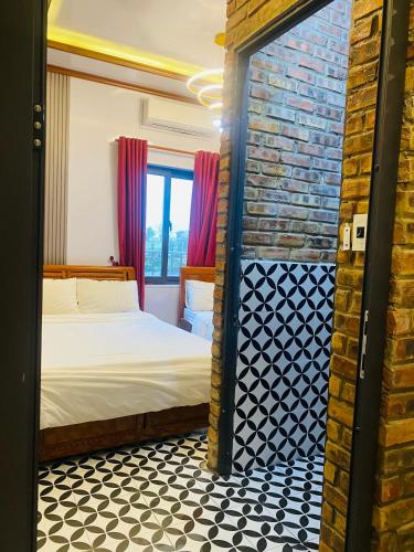 a bedroom with a bed and a brick wall at Sunshine villa thuan an in Hue