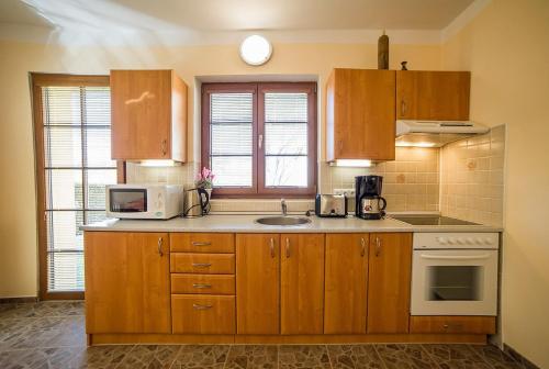 a kitchen with wooden cabinets and a microwave at Pension Jana in Český Krumlov
