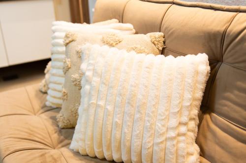 a couch with white pillows on it at Melody Apartments ubicada en el Centro de Santa cruz - Edificio Fiori in Santa Cruz de la Sierra
