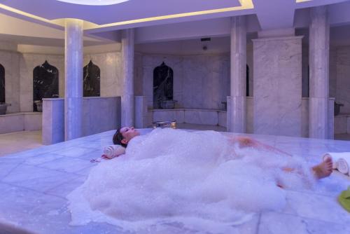 a person laying in a tub of foam at Le Bleu Hotel & Resort Kusadasi in Kusadası