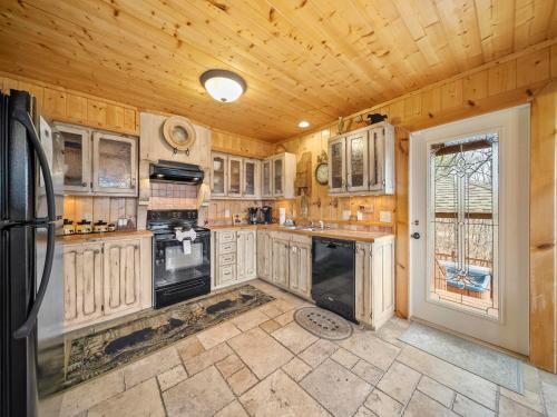 a kitchen with white cabinets and black appliances at Edens View in Gatlinburg