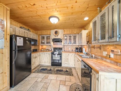 a kitchen with wooden cabinets and a black refrigerator at Edens View in Gatlinburg