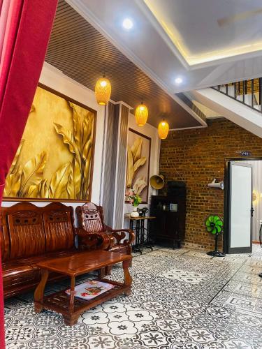 a living room with a couch and a wall at Sunshine villa thuan an in Hue