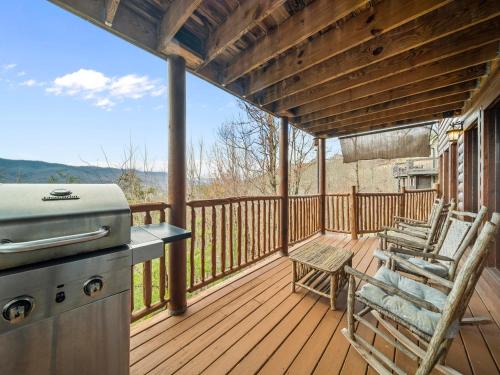 a screened in porch with a grill and two chairs at Edens View in Gatlinburg