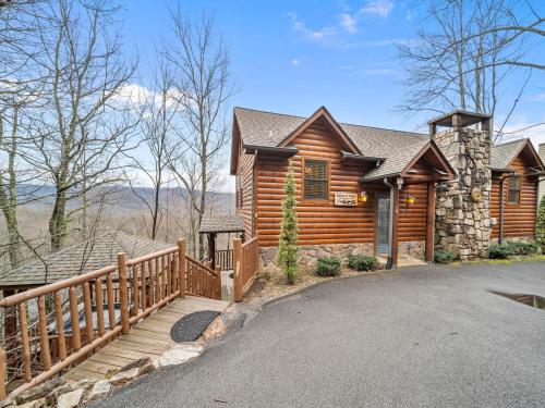 a log cabin with a wooden fence and a driveway at Edens View in Gatlinburg
