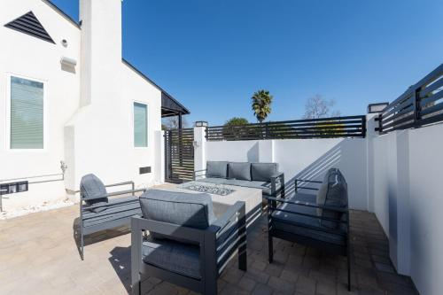 a patio with chairs and a table and a couch at Gated Private Home next to Universal Studios in Van Nuys County Court Heliport