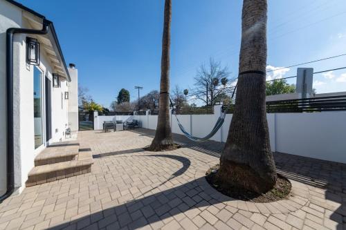 two palm trees on a sidewalk with a bench at Gated Private Home next to Universal Studios in Van Nuys County Court Heliport