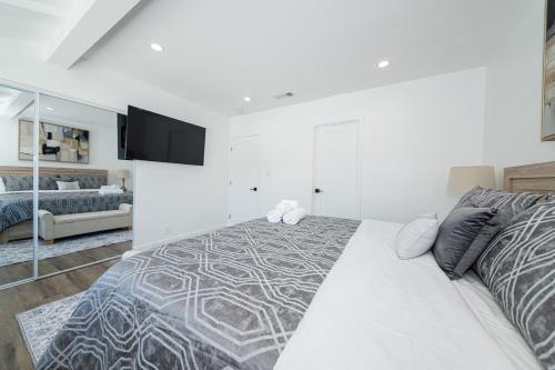 a white bedroom with a bed and a couch at Gated Private Home next to Universal Studios in Van Nuys County Court Heliport