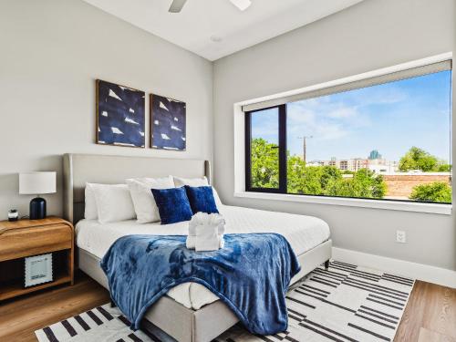 una camera da letto con un letto e una grande finestra di Flawless New Modern Magnolia Townhome a Fort Worth