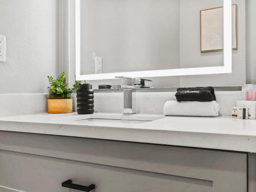 un bagno bianco con lavandino e specchio di Flawless New Modern Magnolia Townhome a Fort Worth