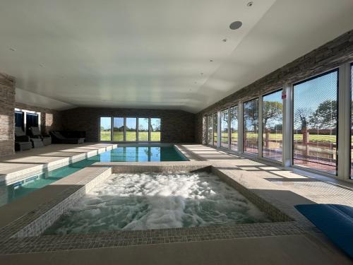 a large swimming pool in a room with windows at Four Bedroom House With Private Pool - Stunning countryside location with parking close to Chester City Centre in Chester
