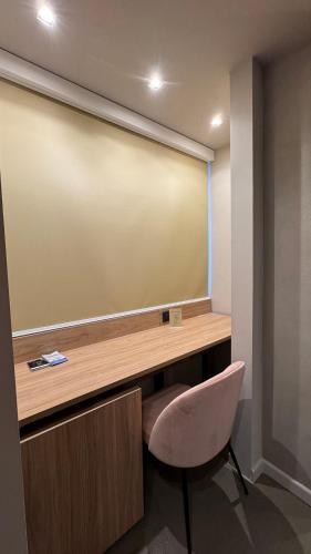 ein Schreibtisch und ein Stuhl vor einer Projektionsfläche in der Unterkunft Tropicana Room in Caserta