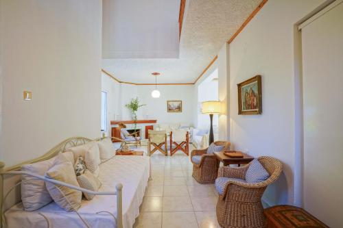 sala de estar con sofá y sillas de mimbre en Makyneia Garden House, en Manglaraíika