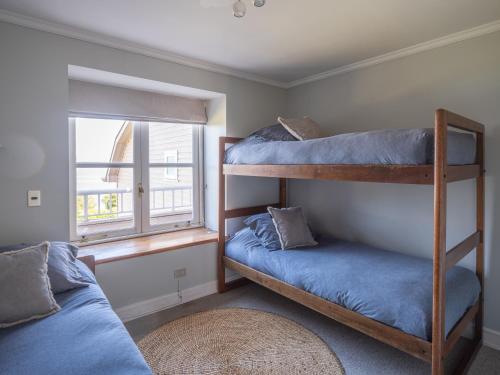 two bunk beds in a room with a window at Bahía Coique in Futrono