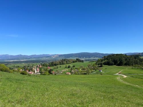 a green field with a village in the distance at Apartmán Linden in Sklené