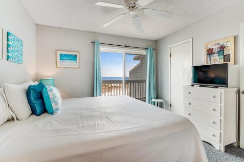 a bedroom with a white bed and a television at Fort Morgan Townhomes E7 in Fort Morgan