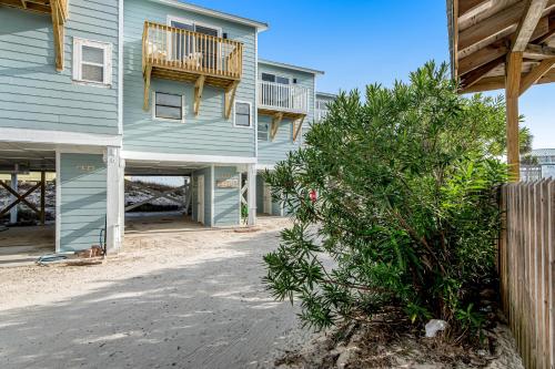 a blue house with a tree in front of it at Fort Morgan Townhomes E7 in Fort Morgan