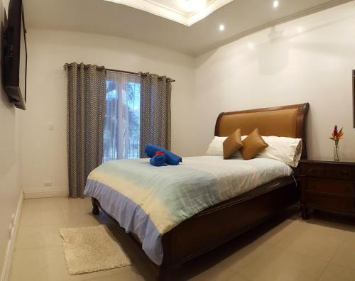 a bedroom with a bed with a blue stuffed animal on it at Condo Niko - Centrally Located, Steps to Beach! in Tamarindo