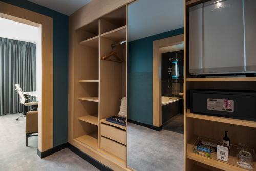 a room with a closet with a television and a room with a table at Novotel Bogota Parque 93 in Bogotá