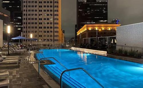 a large swimming pool with blue water at night at Snazzy 3 Bedroom High Rise with Pool, Hot Tub and Rooftop Deck in Los Angeles
