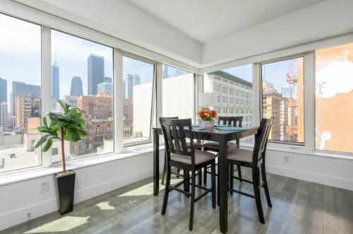 a dining room with a table and chairs and windows at Snazzy 3 Bedroom High Rise with Pool, Hot Tub and Rooftop Deck in Los Angeles