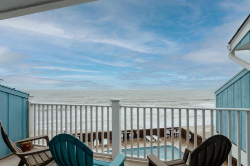 a balcony with chairs and a view of the ocean at Rudicile by Bryant Real Estate in Kure Beach