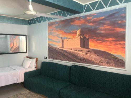 un soggiorno con divano e un grande dipinto sul muro di HAWATY NUBA DWeLL a Nag` el-Ramla