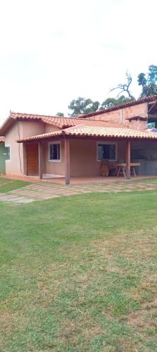 a house with a grass field in front of it at casa temporada capitólio in Capitólio
