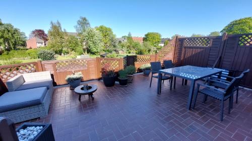 a patio with a table and chairs and potted plants at Watt'n Haven in Wilhelmshaven
