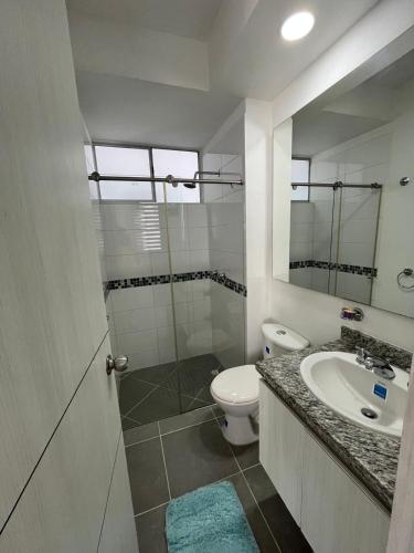 a bathroom with a sink and a toilet and a mirror at Apartamento Conjunto Aqualina Orange in Girardot