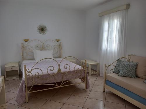 a bedroom with a bed and a couch at Elpidas studios in Agia Anna Naxos