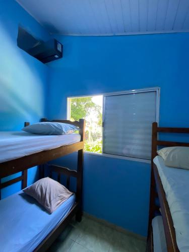 a room with two bunk beds and a window at Casa de férias em trindade paraty in Paraty