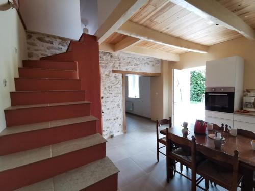 une cuisine et une salle à manger avec un escalier et une table dans l'établissement Au repos du Dourmeur, à Saint-Évarzec