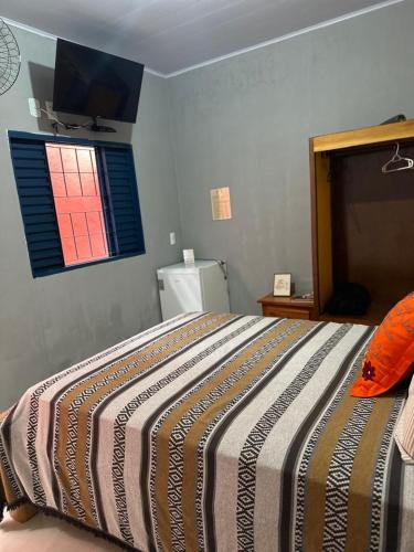 a bedroom with a large bed with a window at Pousada Refúgio Encantado in Goiás
