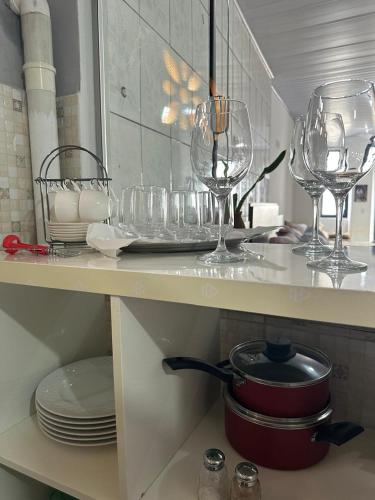 a kitchen counter with wine glasses and plates on it at Pousada Refúgio Encantado in Goiás
