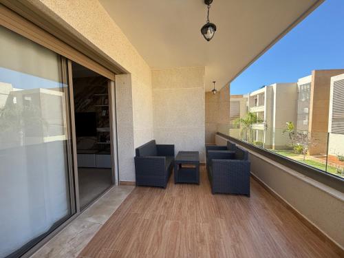 a balcony with chairs and a table on a building at Appartement de très haut Standing à la Marina de Saïdia Résidence TAMARIS 6 piscine VIP in Saidia 