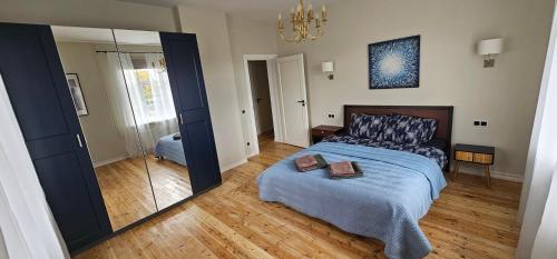a bedroom with a bed and a large mirror at House of the Sun in Ventspils